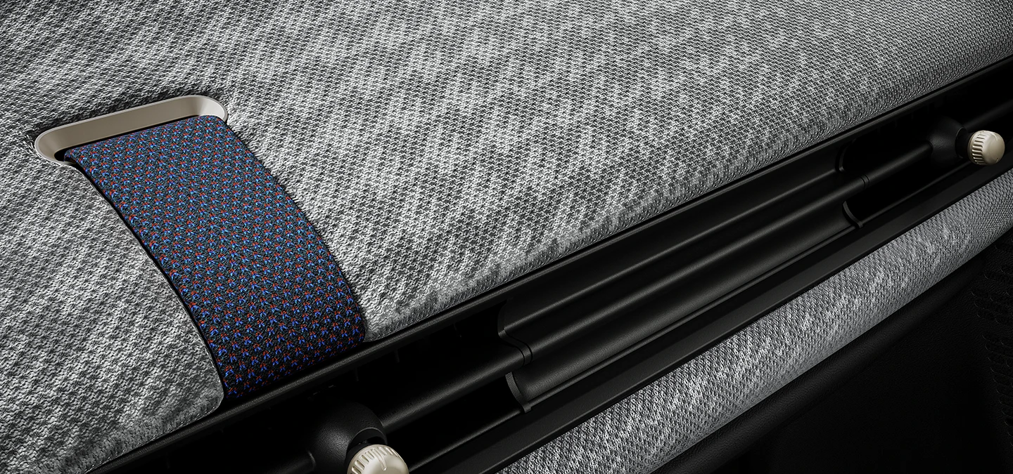 Nahaufnahme des Armaturenbretts eines MINI Cooper mit 2D-Strickbezug.