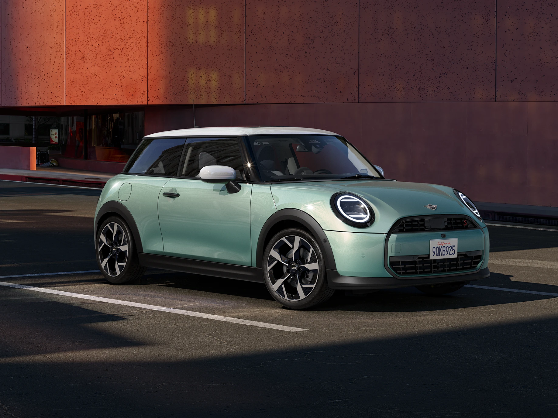 Seitliche Frontansicht des MINI Cooper in Ocean Wave Green mit weißem Dach.