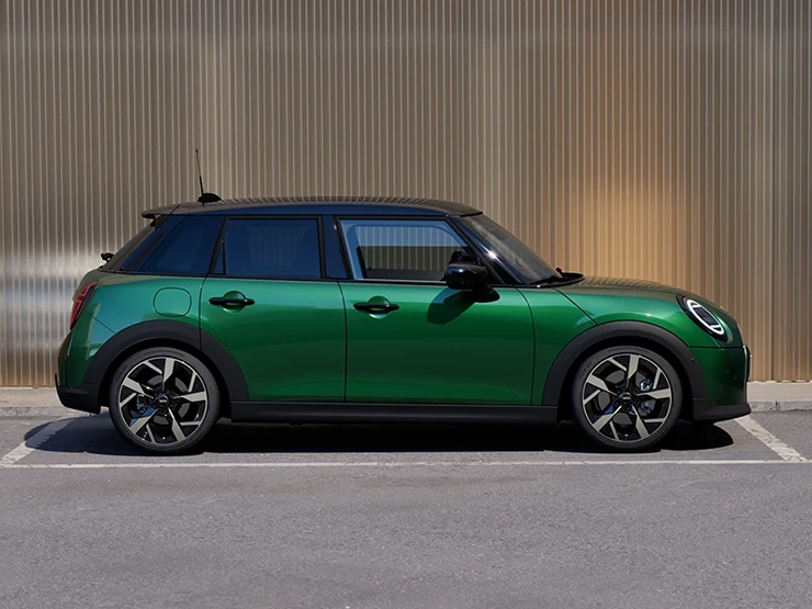 Seitenansicht eines geparkten MINI Cooper 5-Türer in British Racing Green und Dach in Schwarz.