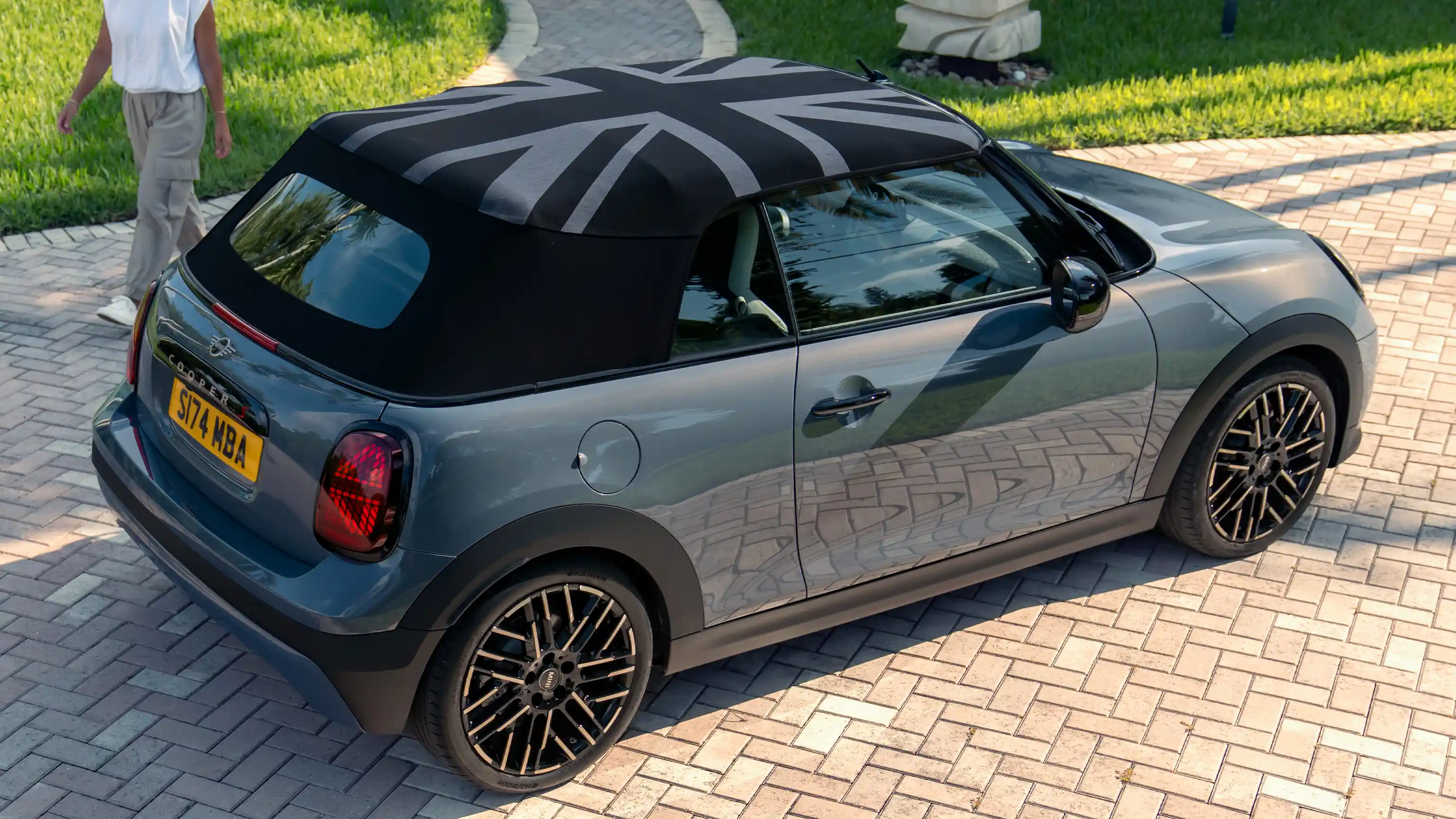 Seitliche Draufsicht auf ein MINI Cooper Cabrio in Copper Grey mit MINI Yours Verdeck