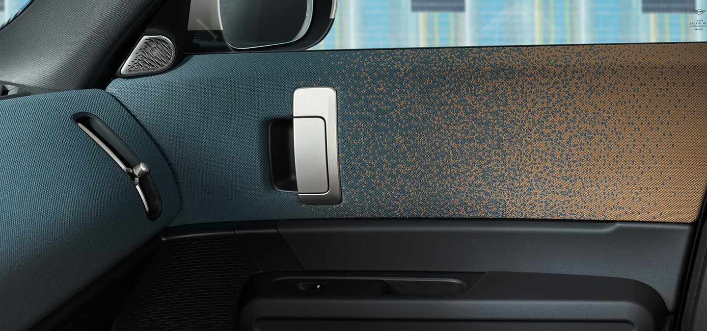 Nahaufnahme des Innendesigns des vollelektrischen MINI Countryman mit Fokus auf Tür und Armaturenbrett.