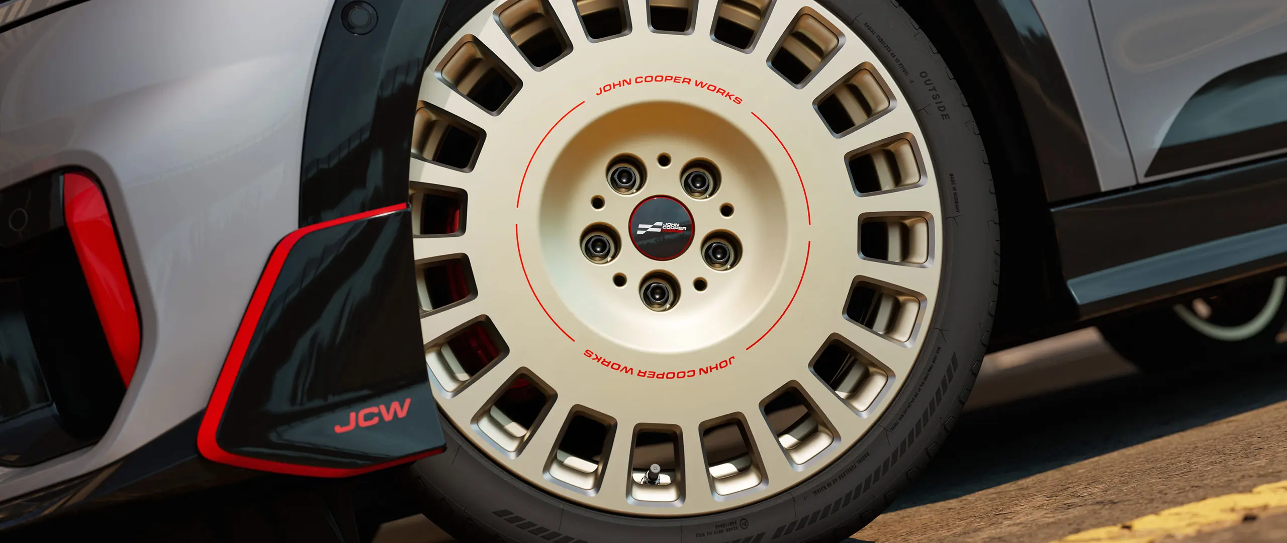 Nahaufnahme der Details auf einem 18-Zoll-Rad JCW Rallye Spoke 964 in Bicolor Vibrant Silver mit glanzgefrästem Front-Winglet.