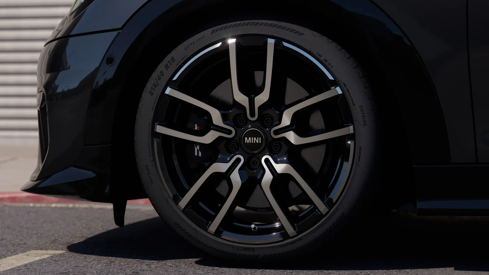 Nahaufnahme des Leichtmetallrads JCW Lap Spoke mit dem charakteristischen Design mit offenen Speichen in Jet Black. 