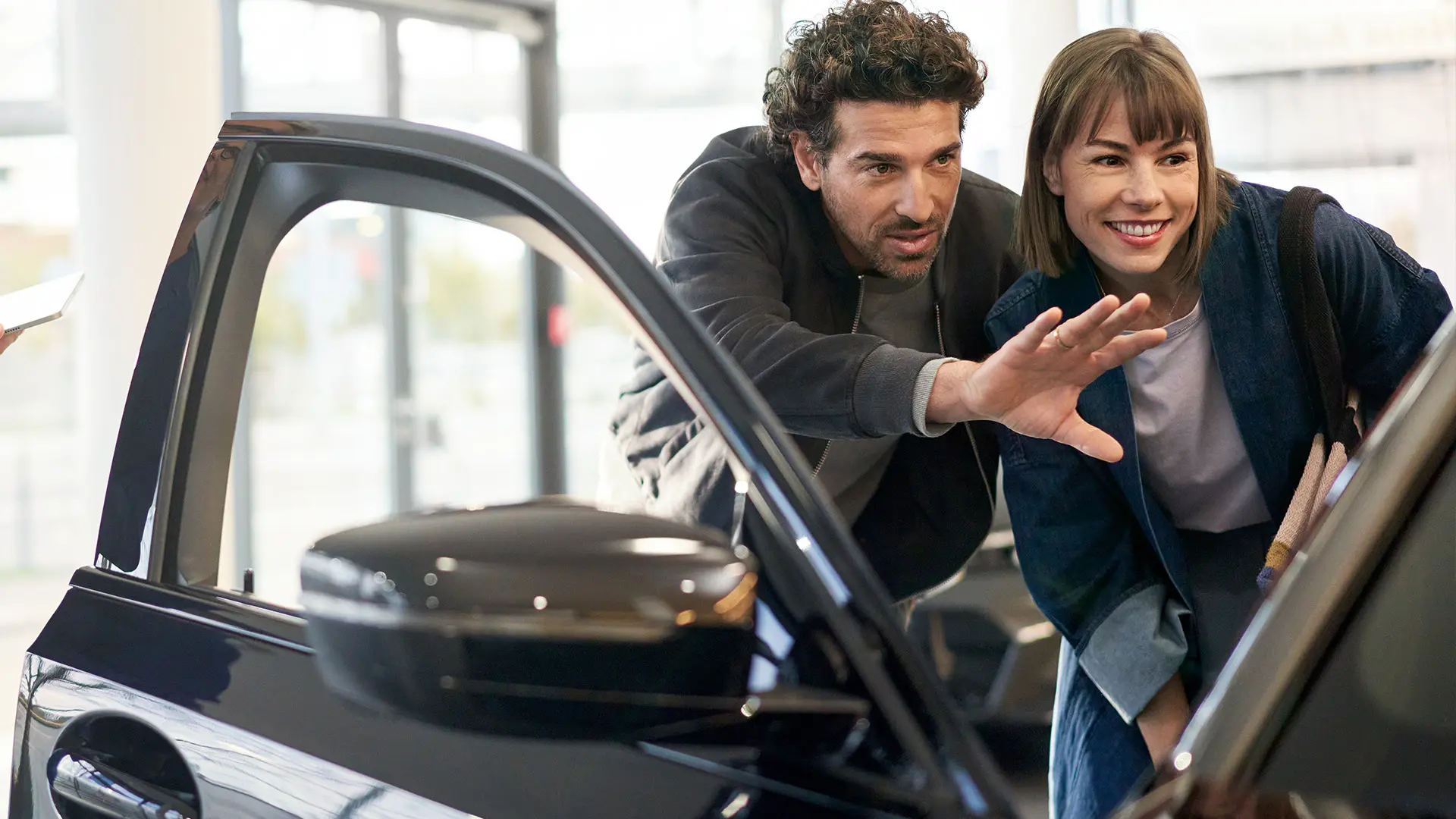 MINI beim MINI Partner mit Agenten, der den Kunden berät und die Innenausstattung erklärt.