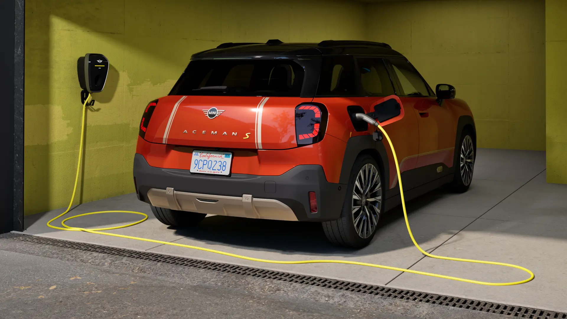 Der vollelektrische MINI Aceman S wird mit der MINI Wallbox Plus geladen, Rückansicht, geparkt in der Garage.