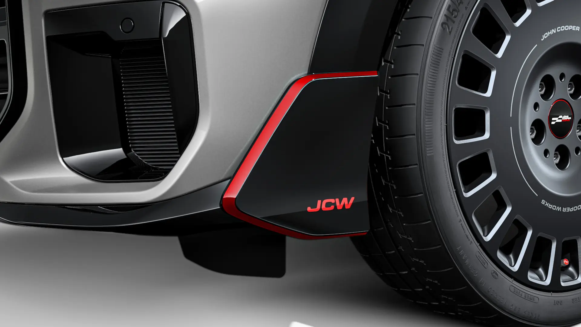 MINI John Cooper Works Front-Winglet in Hochglanz-Schwarz mit rotem JCW Schriftzug und Akzentstreifen.
