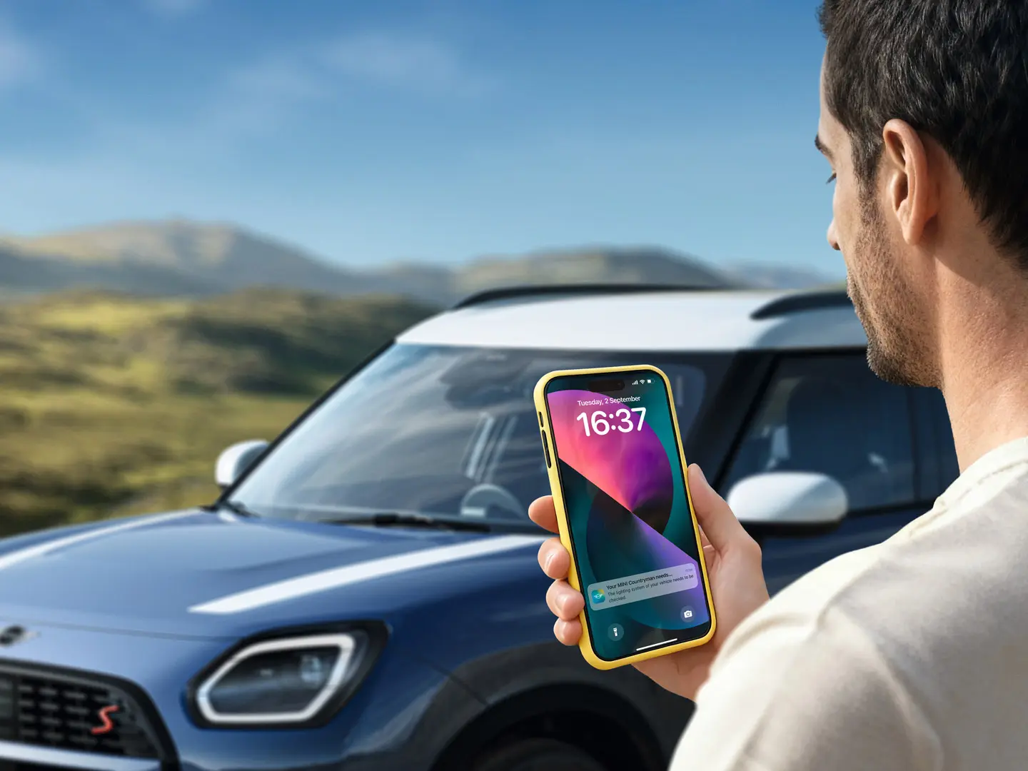 Der Fahrer eines MINI Countryman nutzt die MINI App, um die MINI Pannenhilfe zu kontaktieren. 