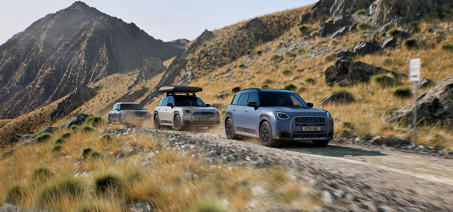Bild von mehreren MINI Countryman Untamed Edition-Modellen, die auf einer Bergstraße im Gelände fahren.