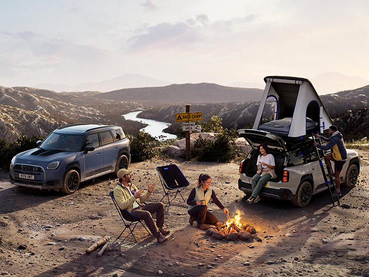 Bild von zwei MINI Countryman Untamed Edition-Fahrzeugen auf einem Berg bei Sonnenuntergang.