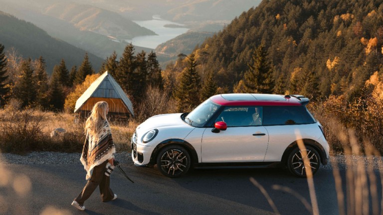 Ein MINI Cooper fährt dynamisch um die Kurve. 