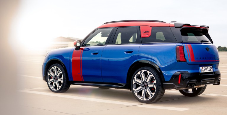 MINI Countryman in blazing blue mit JCW Folierung in chilli red, Seitenansicht.