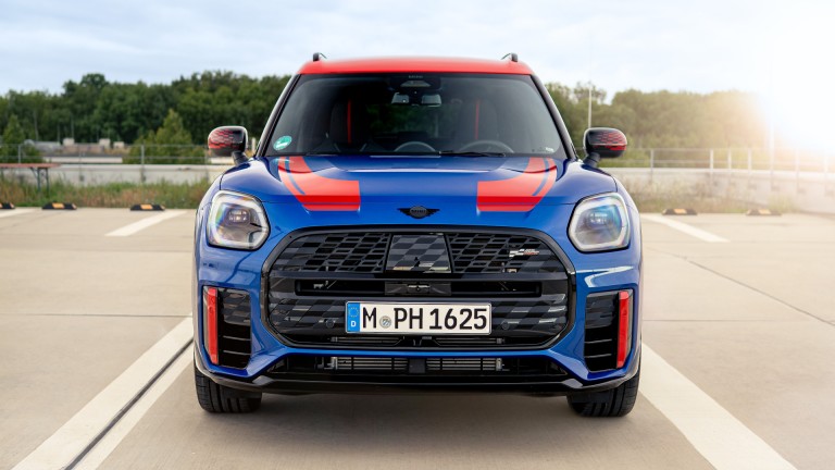  MINI Countryman in blazing blue mit JCW Folierung in chilli red, Frontalansicht.