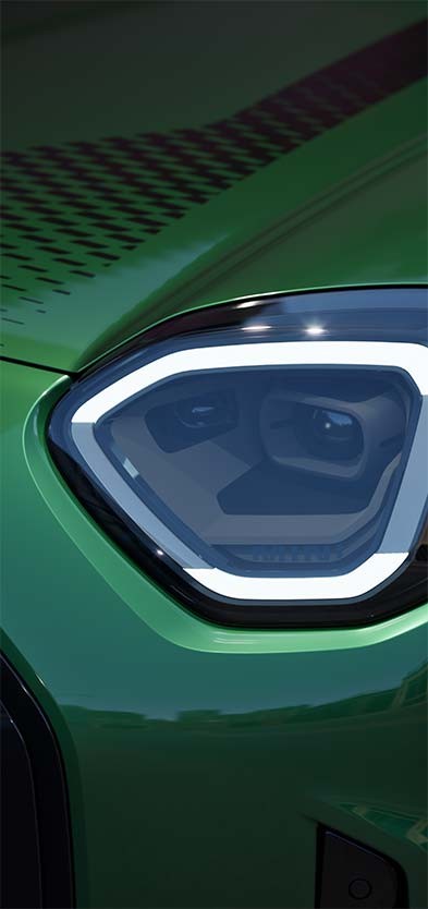 Detailansicht der Scheinwerfer des vollelektrischen MINI Aceman mit aktiviertem weissem Licht