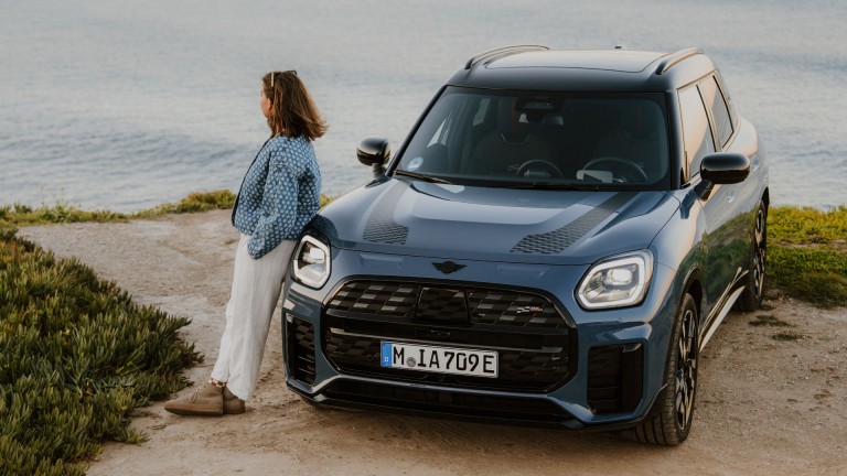 Person angelehnt an einen MINI Countryman.