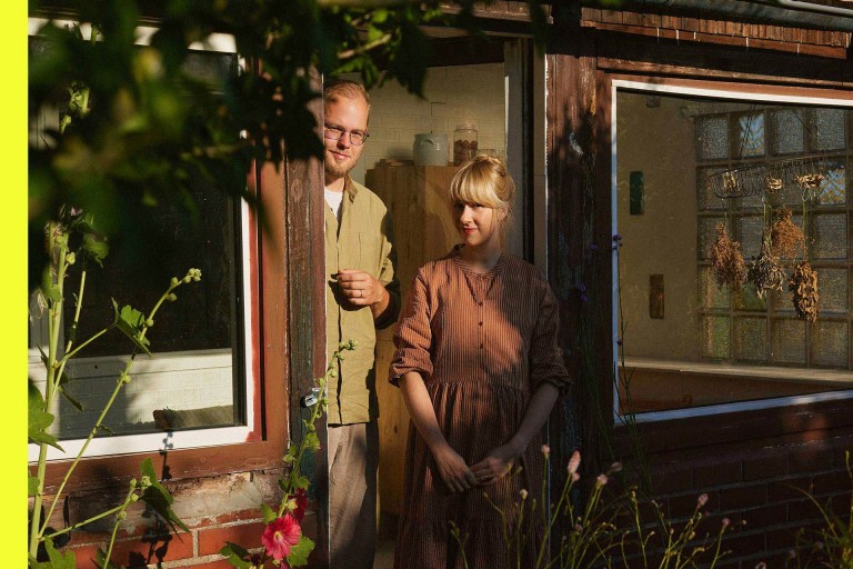 Anne Peter und Jens Amende stehen im Türrahmen ihrer Gartenlaube, die zu ihrem Schrebergarten „Nyponhus“ gehört. 